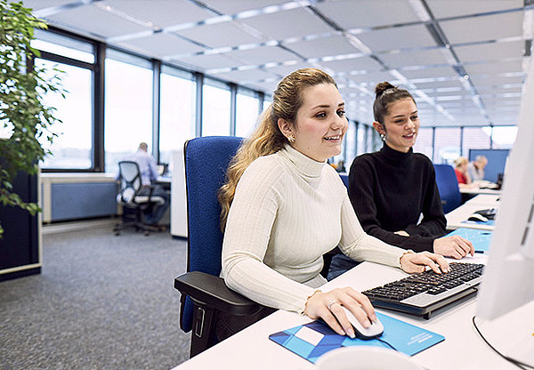 Zwei Mitarbeiterinnen arbeiten zusammen an einem Computer